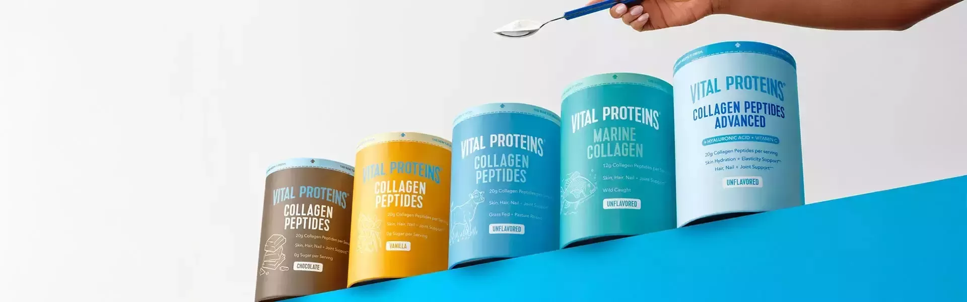 Cutii de suplimente cu colagen Vital Proteins expuse, având deasupra o linguriță plină cu pulbere.