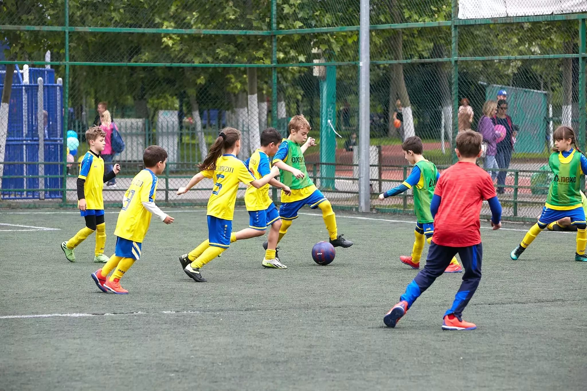 Grup de copii jucand fotbal.