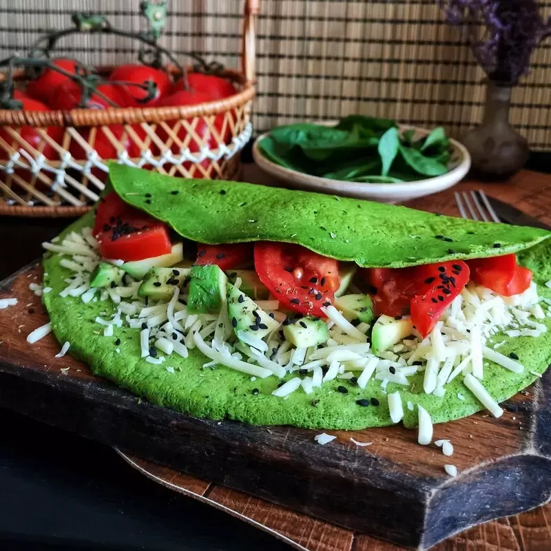 "Clătită din spanac, umplută cu avocado, cașcaval și roșii